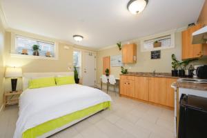 1 Schlafzimmer mit einem großen Bett und einer Küche in der Unterkunft Oakridge Cozy Guesthouse in Vancouver
