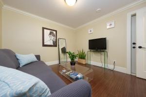 un soggiorno con divano e TV di Oakridge Cozy Guesthouse a Vancouver