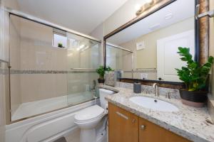 ein Badezimmer mit einem WC, einem Waschbecken und einem Spiegel in der Unterkunft Oakridge Cozy Guesthouse in Vancouver