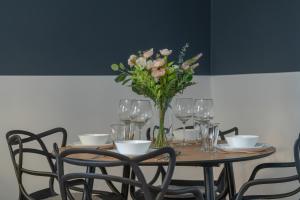 a table with a vase of flowers and wine glasses at Elegant Apartment near to the Centre of Poznań by Rent like home in Poznań