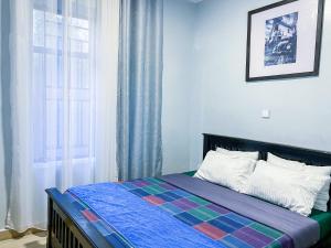 a bed in a room with a window and a bed sidx sidx sidx at Umuringa Stay in Kigombe