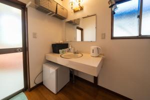 ein Bad mit einem Waschbecken und einem Spiegel in der Unterkunft グランドホテル成田空港 in Akaike