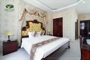 Un dormitorio con una gran cama blanca en una habitación. en Victory Hotel Old Wing, en Vung Tau
