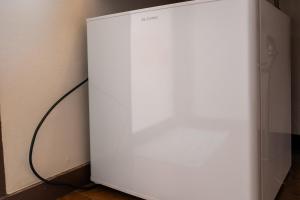 a white refrigerator sitting next to a wall at グランドホテル成田空港 in Akaike