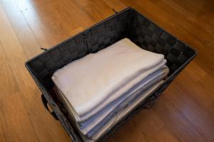 a black basket filled with towels on a wooden floor at グランドホテル成田空港 in Akaike