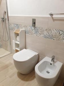 a bathroom with a white toilet and a sink at Villetta Fiorita in San Vito lo Capo