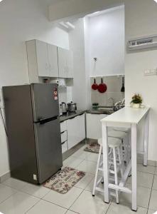 a kitchen with a refrigerator and a table in it at Camelia Youth City Nilai Studio residence 5pax in Nilai