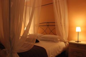 a bedroom with a canopy bed with white curtains at Villa Egle in Antronapiana