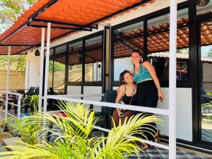 duas mulheres paradas na frente de uma casa em LAKSHDEEP COTTAGES em Canacona
