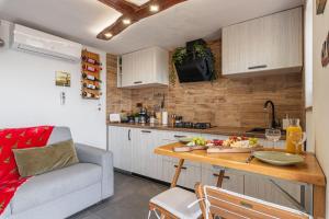 eine Küche mit einem Tisch und einem Sofa in einem Zimmer in der Unterkunft Vineyard Cottage Sunny Hill - Happy Rentals in Mirna