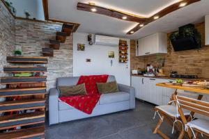 ein Wohnzimmer mit einem Sofa und einem Tisch sowie eine Küche in der Unterkunft Vineyard Cottage Sunny Hill - Happy Rentals in Mirna