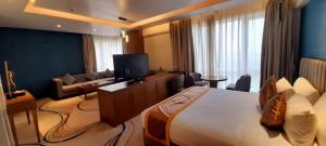 a hotel room with a large bed and a television at Wonder Country-Club in Barādiha