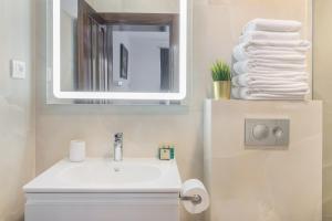 La salle de bains est pourvue d'un lavabo, d'un miroir et de serviettes. dans l'établissement Thermalis Grove Private House, à Băile Felix