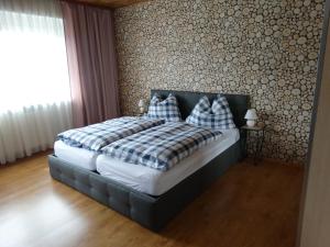 a bedroom with a bed with plaid pillows on it at Haus Frans Josef in Seeboden