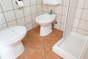 a bathroom with a toilet and a sink and a shower at Agriturismo S'Ispiga in Cuglieri
