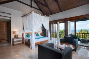 a bedroom with a bed with a canopy at Blue Point Resort and Spa in Uluwatu