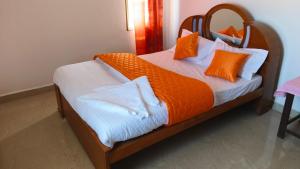 1 dormitorio con 1 cama con almohadas de color naranja y blanco en Paradise Villa, en Pūrnānkuppam