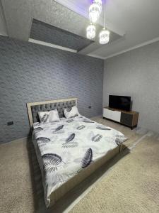 um quarto com uma cama grande e uma televisão em “DACHA” Hi-Tech by Dubai em Aranchi