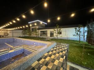 uma casa com piscina à noite em “DACHA” Hi-Tech by Dubai em Aranchi