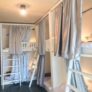 a room with two bunk beds and a ladder at Lay low hostel in Ubon Ratchathani