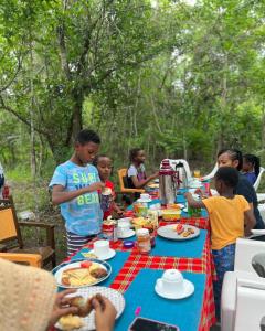 un grupo de niños parados alrededor de una mesa con comida en KARUSIRO FARM AND COUNTRY PARK, en Kibaha