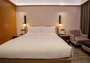 安吉県にあるHentique Resort Anjiのベッドルーム(大きな白いベッド1台、椅子付)