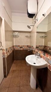 W łazience znajduje się biała umywalka i lustro. w obiekcie RAATREE w mieście Mysuru