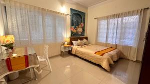 een slaapkamer met een bed, een bureau en een raam bij RAATREE in Mysore