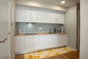 a kitchen with white cabinets and a rug on the floor at APARTAMENTO AZUL in Salvatierra de Miño