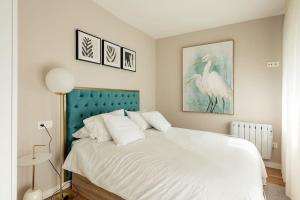 1 dormitorio con cama blanca y cabecero azul en APARTAMENTO AZUL, en Salvatierra de Miño