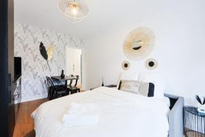 - une chambre avec un lit blanc et un miroir dans l'établissement Appartement très luxueux avec terrasse, à Bagnolet