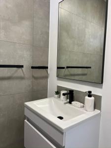 a bathroom with a white sink and a mirror at Tocara Lifestyle Estate: Fourways in Johannesburg