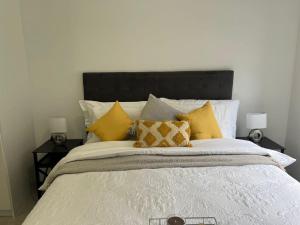a bedroom with a large bed with yellow pillows at Tocara Lifestyle Estate: Fourways in Johannesburg