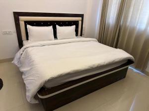 a large bed with white sheets and pillows at Hotel Ningbo Udaipur in Udaipur