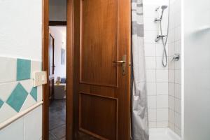 a bathroom with a shower and a wooden door at Mare e natura in Posada