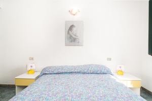 a bedroom with a bed and two nightstands with two lamps at Mare e natura in Posada