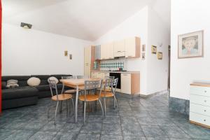a kitchen and living room with a table and chairs at Mare e natura in Posada