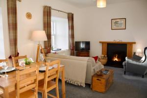 a living room with a couch and a fireplace at Normanns Ruh in Ballygown