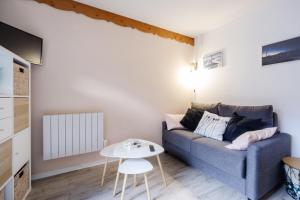 a living room with a blue couch and a table at Appartement Front De Neige in Termignon