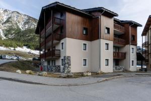 an apartment building in the mountains with a parking lot at Appartement Front De Neige in Termignon