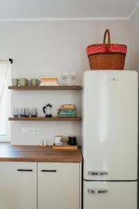 a kitchen with a white refrigerator with a basket on top at Apartament ACTIV jezioro góry in Żywiec
