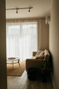 a living room with a couch and a large window at Apartament ACTIV jezioro góry in Żywiec