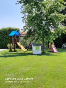 a playground with two slides and a tree at Agriturismo Ai Carpini in Marcon