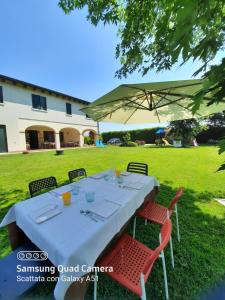 a table with chairs and an umbrella in a yard at Agriturismo Ai Carpini in Marcon