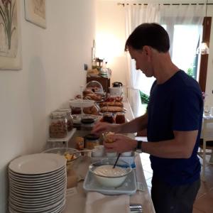 Agriturismo Ai Carpini في ماركون: رجل يعد الطعام في وعاء على منضدة