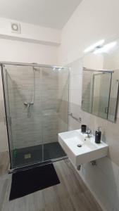 a white bathroom with a shower and a sink at Al Castello in Morano Calabro