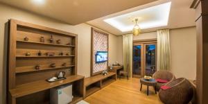 a living room with a table and chairs and a television at Royal Palace Hotel in Nyoungoo