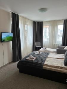 a hotel room with two beds and a flat screen tv at IG Apartments Royal Towers 426 in Bansko