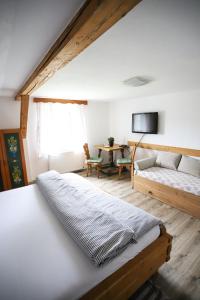 1 dormitorio con cama, sofá y mesa en Penzion Na Gruntu, en Lipná