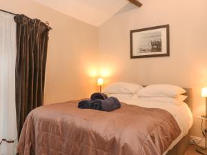 Un dormitorio con una cama con un montón de ropa. en Myrtle Cottage en Windermere